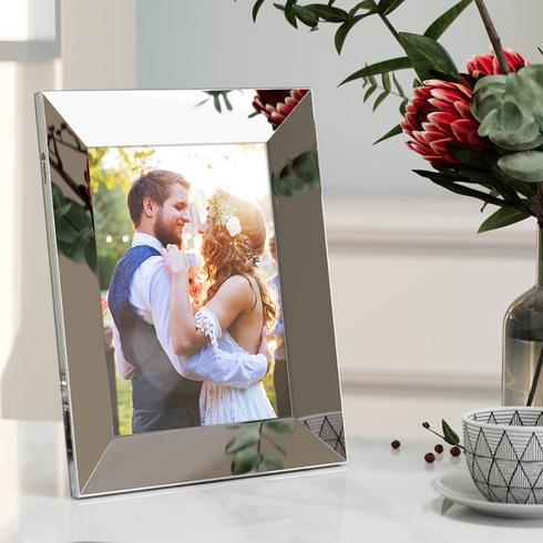 Load your Photos into a Digital Frame A silver digital frame with a wedding photo of a couple.
