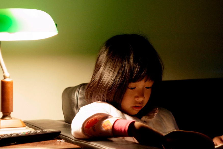 17. Use Desk or Table Lamps Girl reading next to lamp on side table