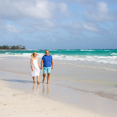 When Did Caerula Mar Open? Sarah and Bryan Baeumler walking along a sandy beach