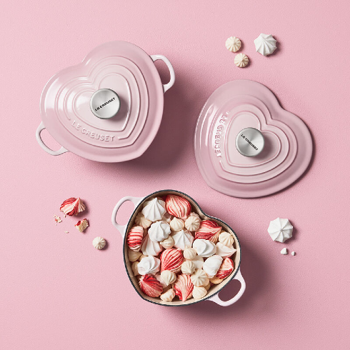 Pink Heart-Shaped Cookware A pink heart-shaped Le Creuset cast iron cookware in a light pink